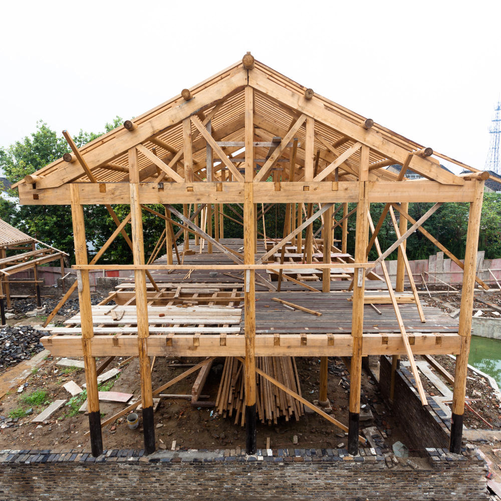 Ouvrier en gants fixant un élément de toiture avec une visseuse, pour assurer une pose précise et durable