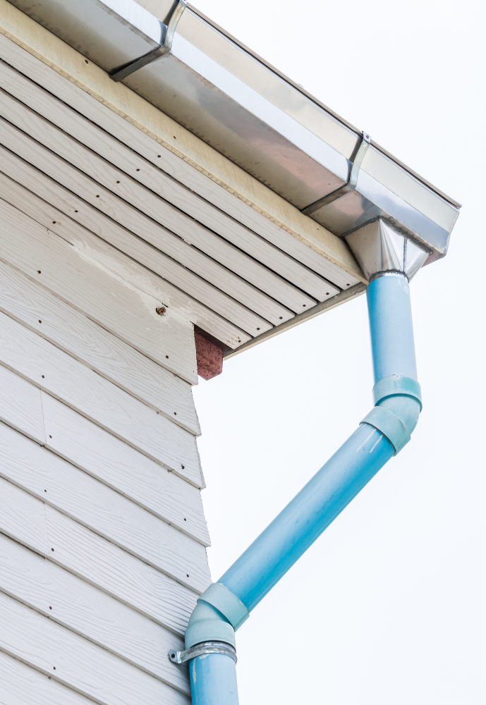 Ouvrier en gants fixant un élément de toiture avec une visseuse, pour assurer une pose précise et durable